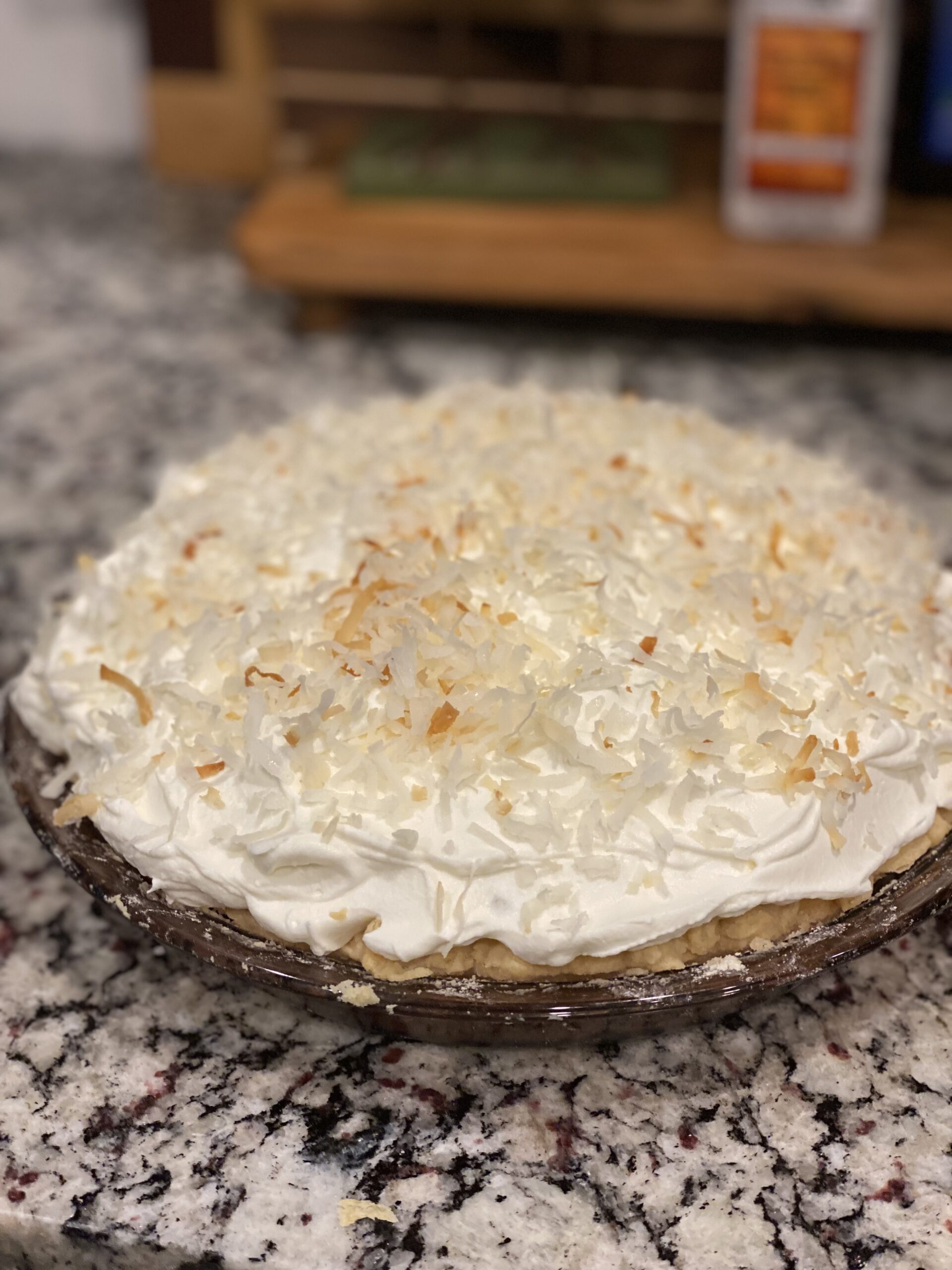 Coconut cream pie topped with whipped cream and toasted coconut