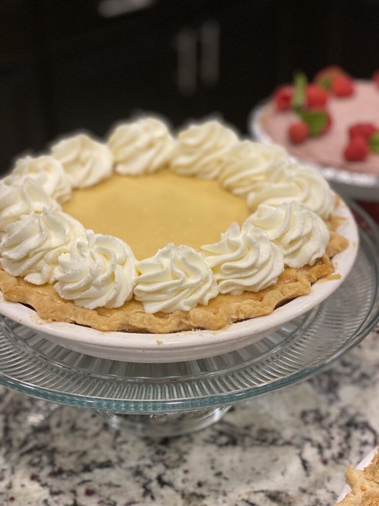 Lemon velvet cream pie topped with whipped cream