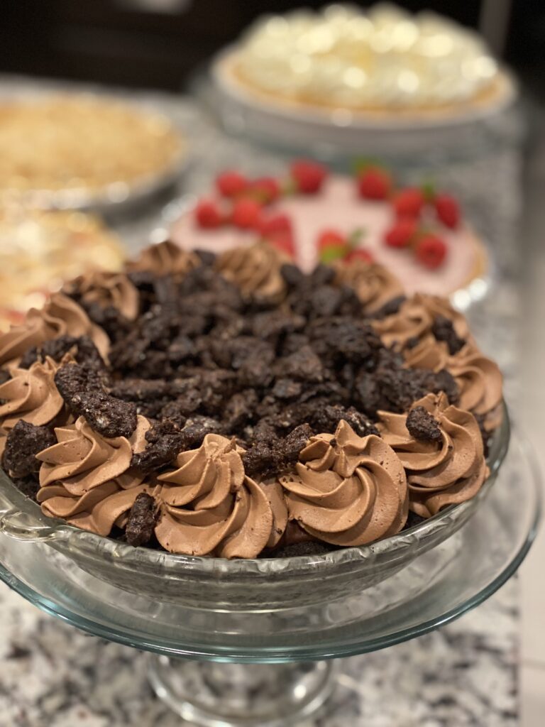 Slice of Mississippi Mud Pie showing layers of Oreo crust, brownie, mousse, and whipped cream