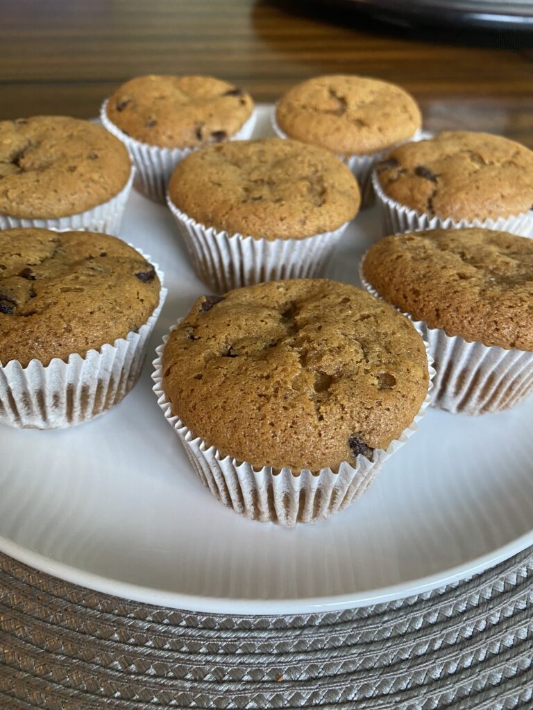 Freshly baked pumpkin chocolate chip muffins cooling on a wire rack.