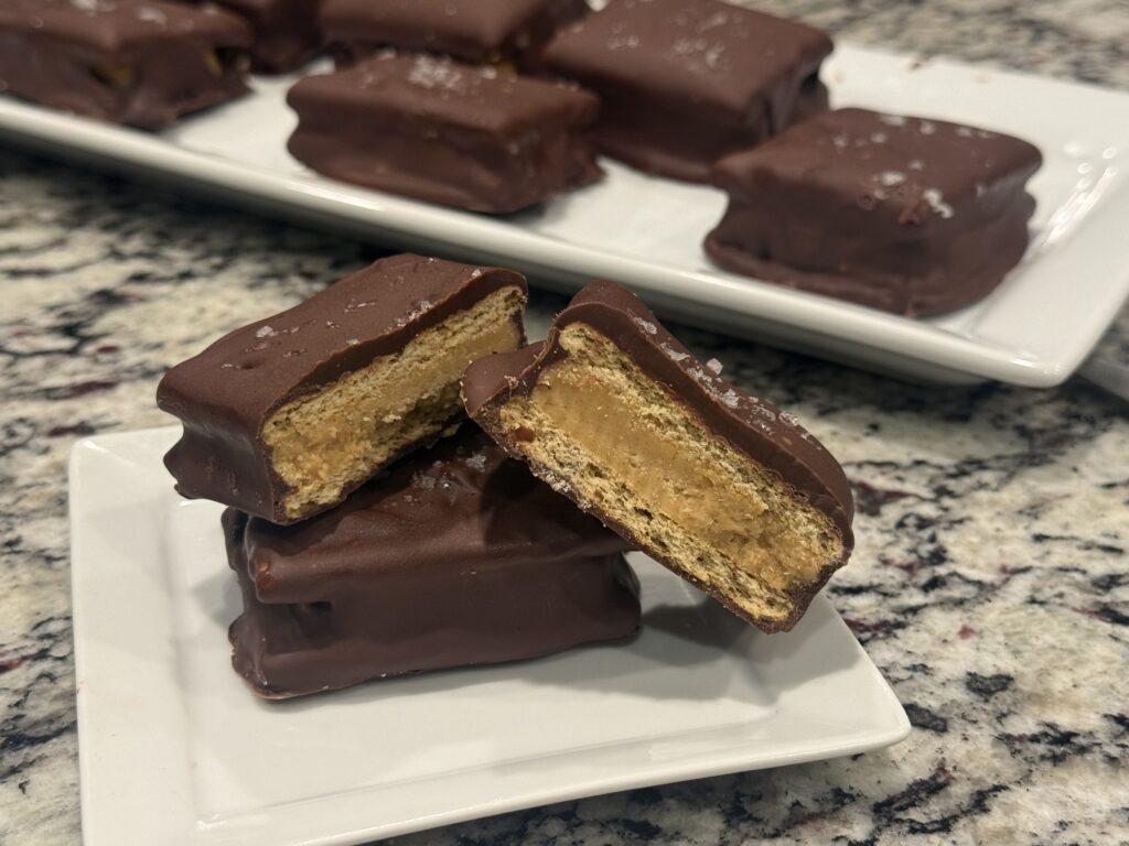 Chocolate-covered Buckeye Graham Crackers filled with creamy peanut butter between graham crackers and topped with flaky sea salt.
