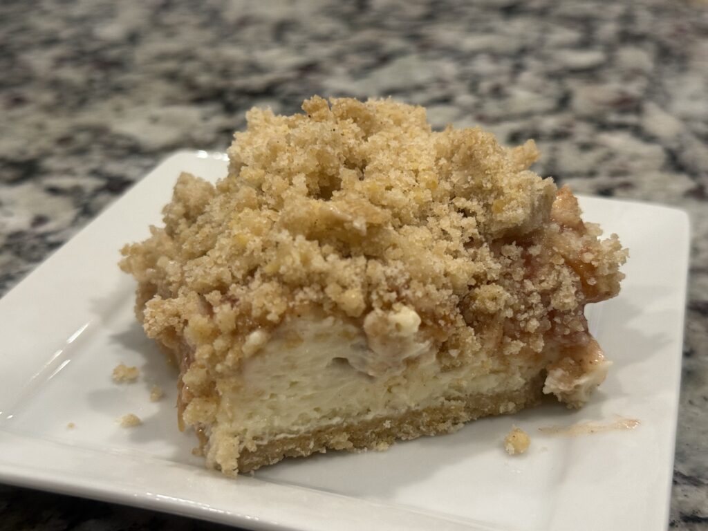 Peach Cheesecake Cobbler made with juicy peaches, a creamy cheesecake layer, and a buttery cobbler topping baked until golden brown.